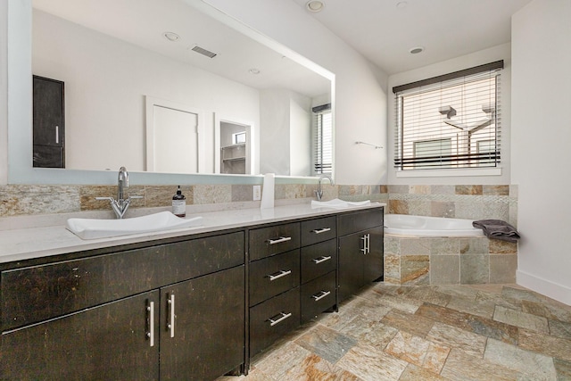 bathroom featuring tiled bath and vanity