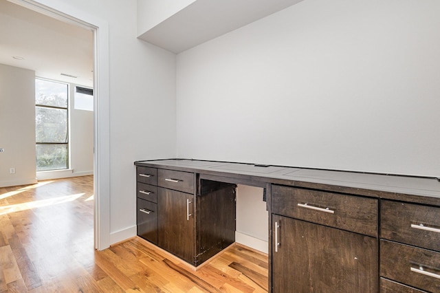 kitchen with light wood-type flooring and dark brown cabinetry