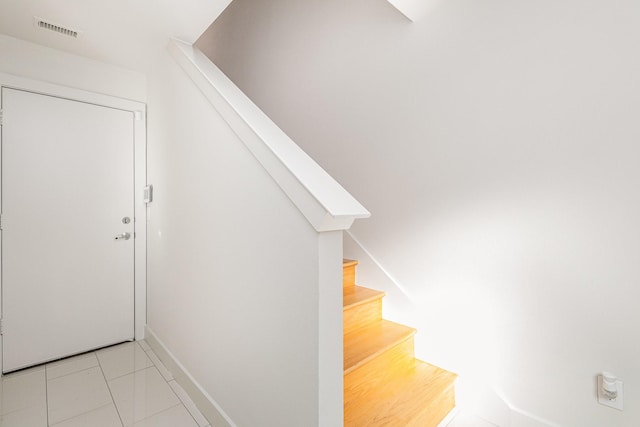 stairway featuring tile patterned flooring