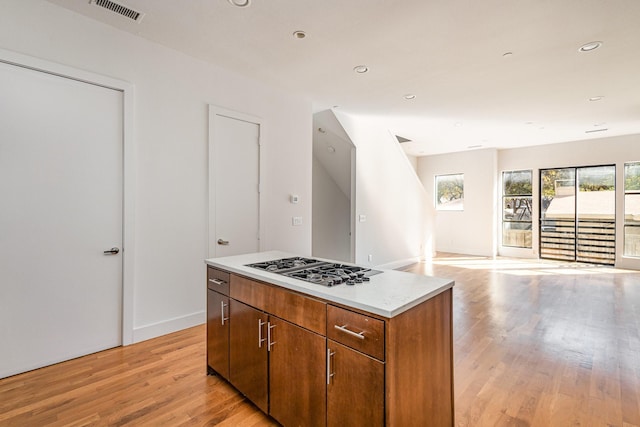 kitchen featuring stainless steel gas stovetop, a center island, and light wood-type flooring