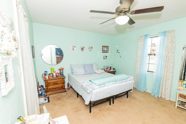 carpeted bedroom featuring a textured ceiling and ceiling fan