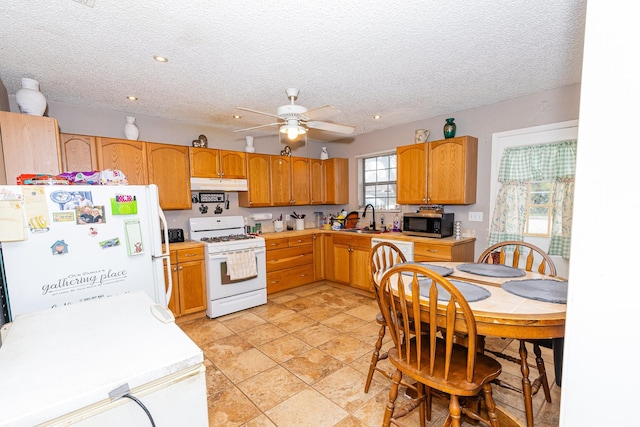 kitchen featuring a textured ceiling, ceiling fan, sink, and white appliances