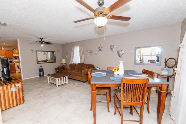 dining space with a textured ceiling and ceiling fan