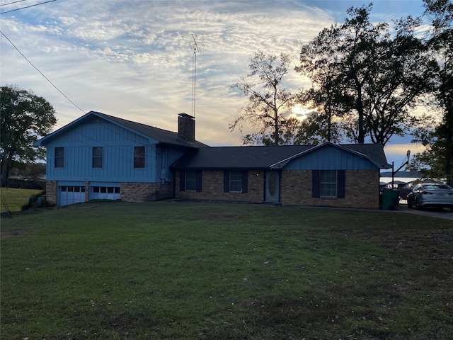 tri-level home featuring a yard and a garage