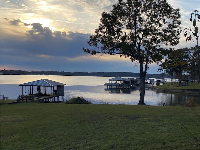 dock area featuring a lawn and a water view