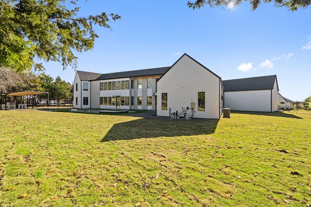 back of property featuring a yard and central air condition unit