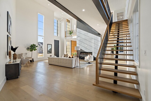 interior space featuring hardwood / wood-style floors, a towering ceiling, and a wealth of natural light