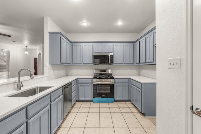 kitchen featuring gray cabinets, sink, light tile patterned floors, and stainless steel appliances