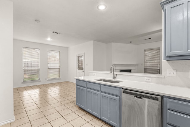 kitchen featuring stainless steel dishwasher, gray cabinetry, light tile patterned floors, and sink