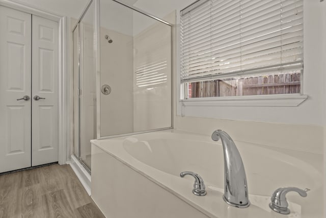 bathroom featuring hardwood / wood-style flooring and shower with separate bathtub