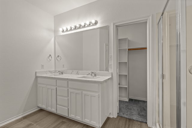 bathroom with wood-type flooring, vanity, and walk in shower