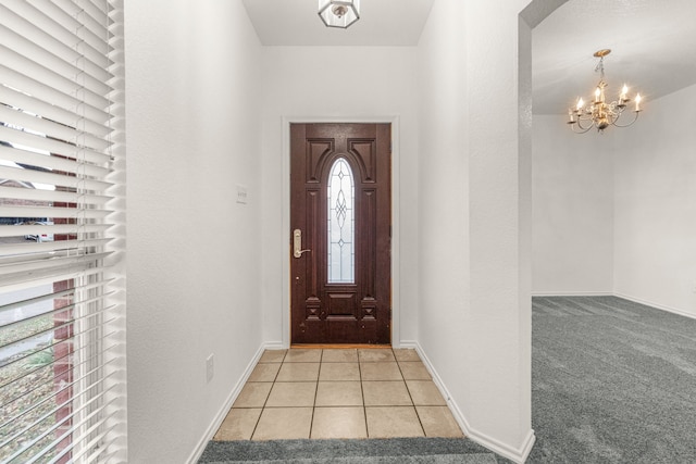 foyer entrance with a wealth of natural light, light colored carpet, and a notable chandelier