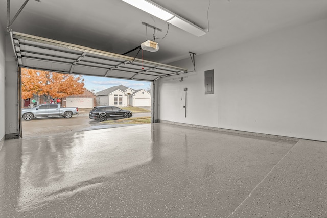 garage with a garage door opener and electric panel