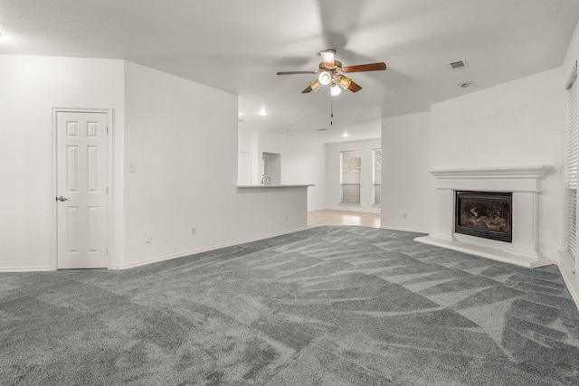 unfurnished living room with carpet flooring and ceiling fan