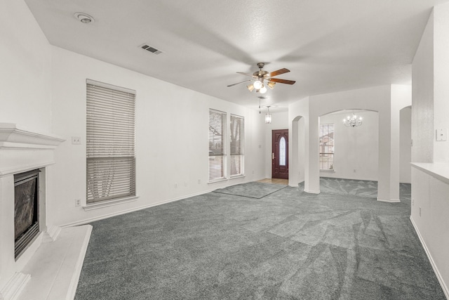 unfurnished living room with ceiling fan with notable chandelier and carpet floors