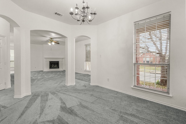 unfurnished living room with carpet and ceiling fan with notable chandelier