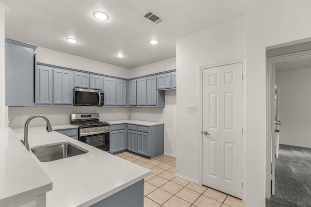 kitchen featuring gray cabinetry, sink, stainless steel appliances, kitchen peninsula, and light tile patterned flooring