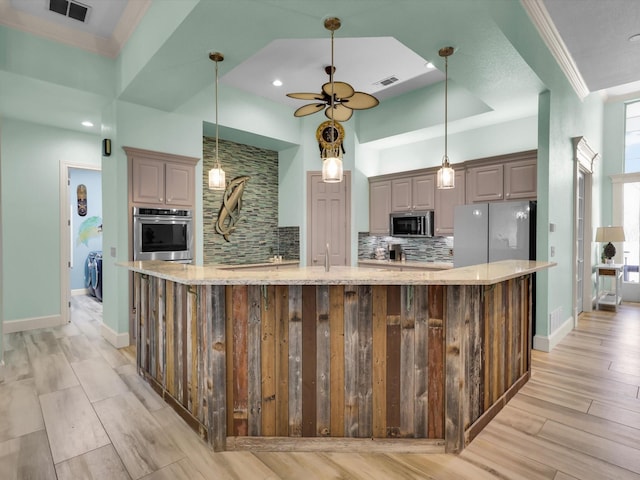 kitchen with ceiling fan, tasteful backsplash, a spacious island, stainless steel appliances, and light stone counters