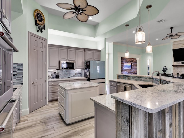 kitchen featuring tasteful backsplash, gray cabinets, sink, stainless steel appliances, and a large island