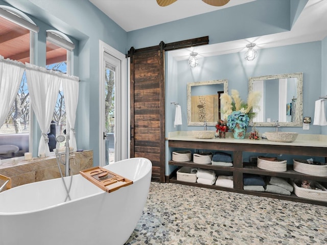 bathroom with ceiling fan, a washtub, and vanity