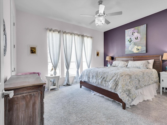 bedroom with ceiling fan, light carpet, and multiple windows