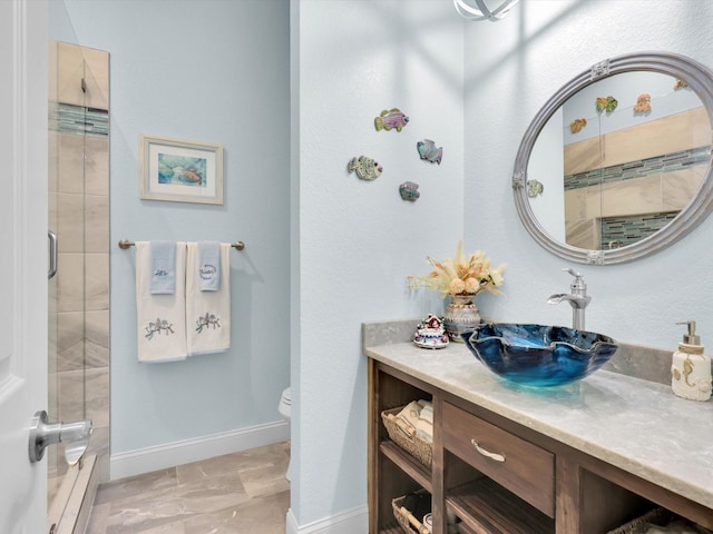 bathroom with an enclosed shower, vanity, and toilet