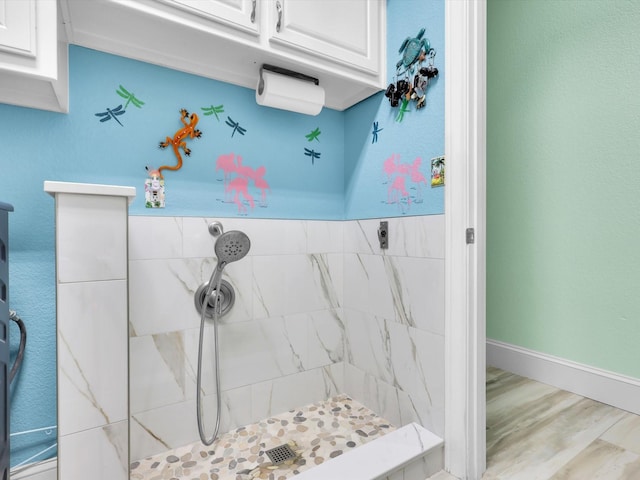 bathroom featuring wood-type flooring and tiled shower