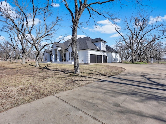 view of property exterior with a garage and a lawn