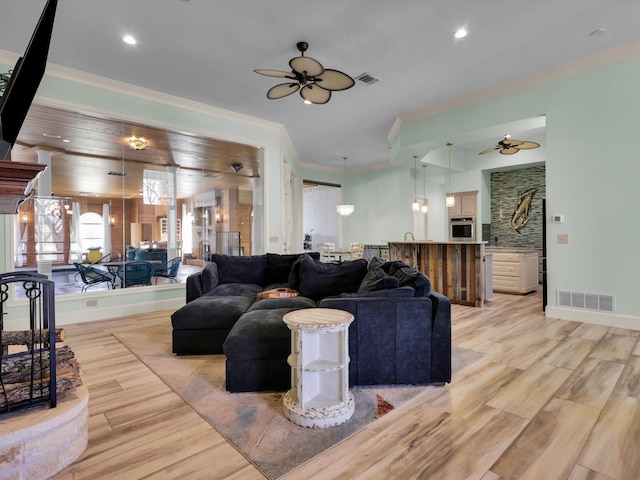 living room featuring ceiling fan, light hardwood / wood-style flooring, and ornamental molding