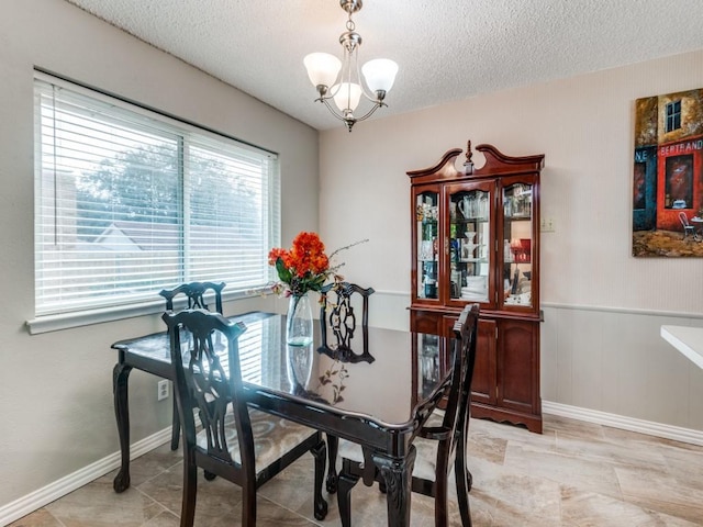 dining area featuring a textured ceiling and a chandelier