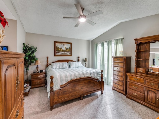 carpeted bedroom featuring ceiling fan, vaulted ceiling, and a textured ceiling