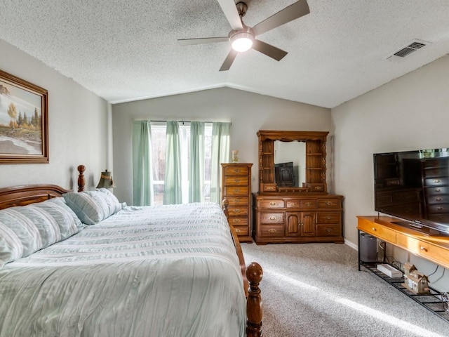 bedroom featuring lofted ceiling, ceiling fan, carpet floors, and a textured ceiling