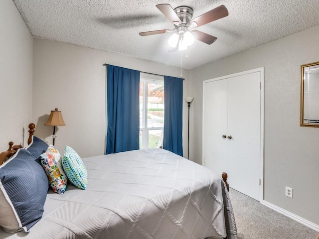 bedroom with ceiling fan, carpet flooring, a textured ceiling, and a closet