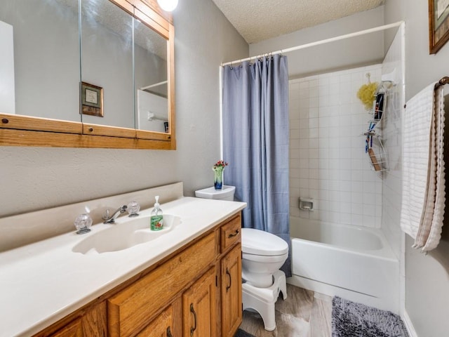 full bathroom featuring vanity, shower / tub combo, toilet, and a textured ceiling