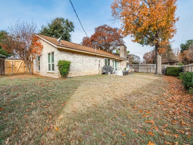 rear view of property featuring a lawn