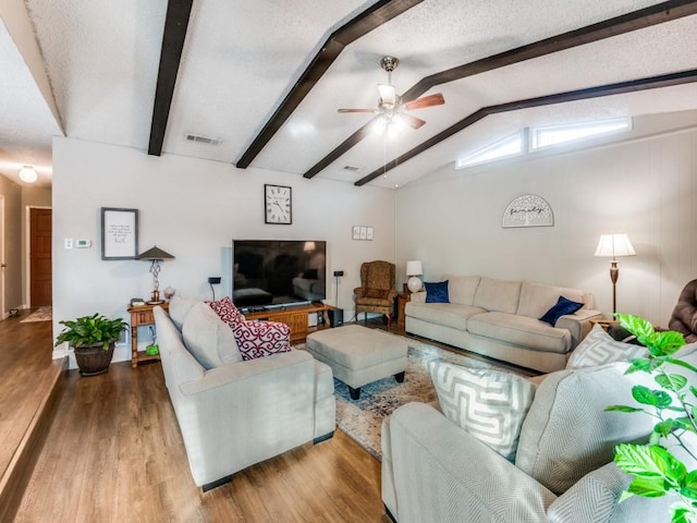 living room featuring ceiling fan, light hardwood / wood-style flooring, lofted ceiling with beams, and a textured ceiling