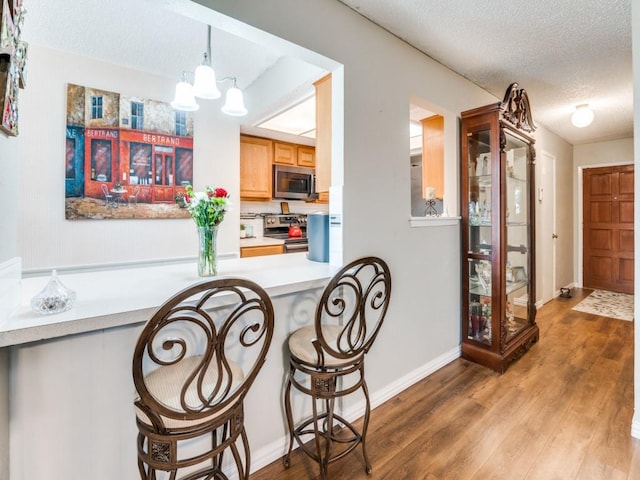 dining area featuring hardwood / wood-style flooring, a chandelier, and a textured ceiling