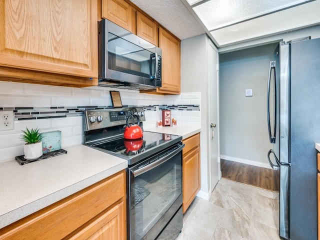 kitchen with stainless steel appliances and decorative backsplash