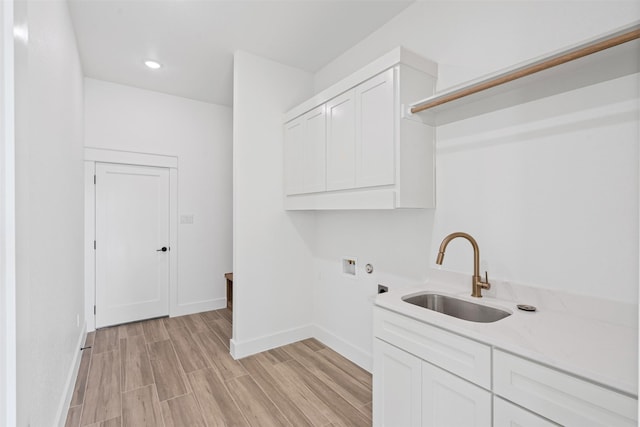 laundry room with sink, cabinets, washer hookup, hookup for an electric dryer, and light hardwood / wood-style floors