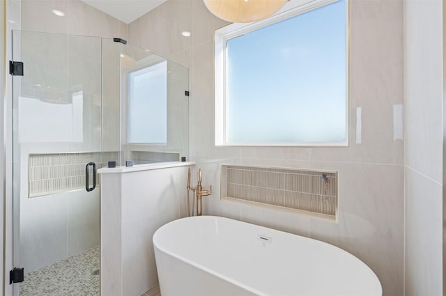 bathroom featuring separate shower and tub and tile walls