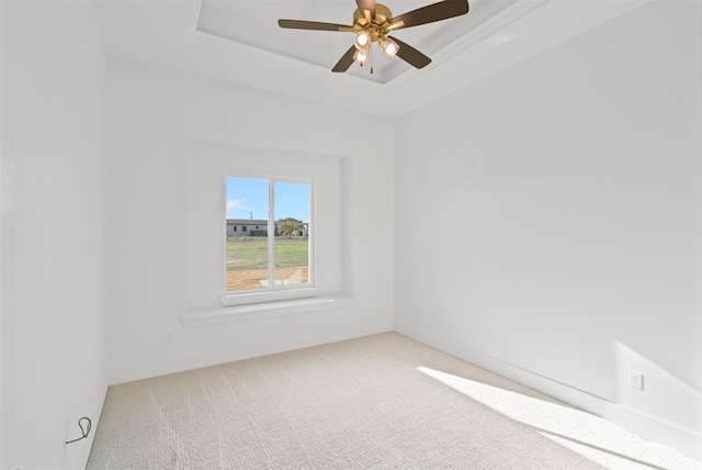 spare room featuring a tray ceiling, ceiling fan, crown molding, and carpet