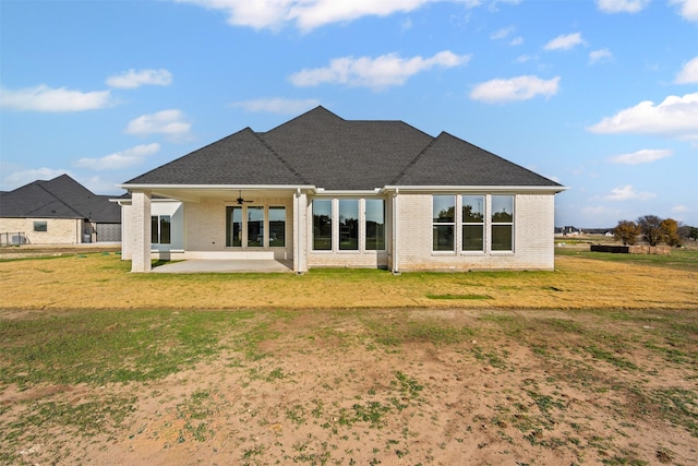 back of property with a yard, a patio, and ceiling fan