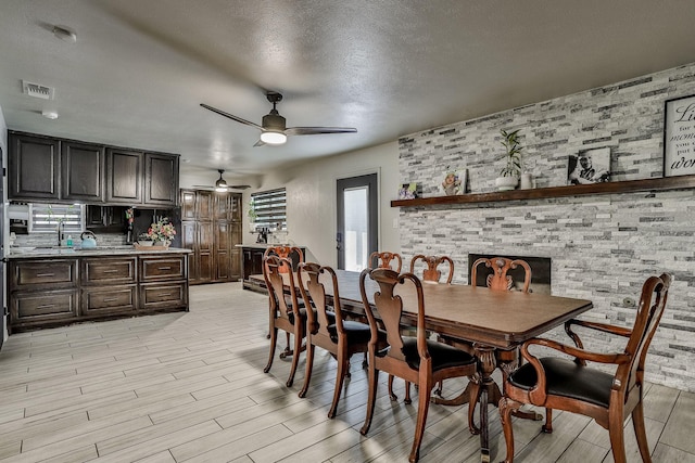 dining area featuring ceiling fan, a textured ceiling, and light wood-type flooring