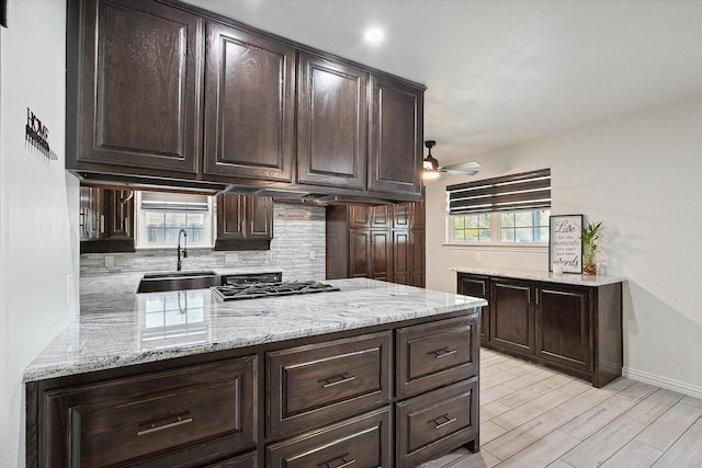 kitchen with sink, backsplash, and dark brown cabinets