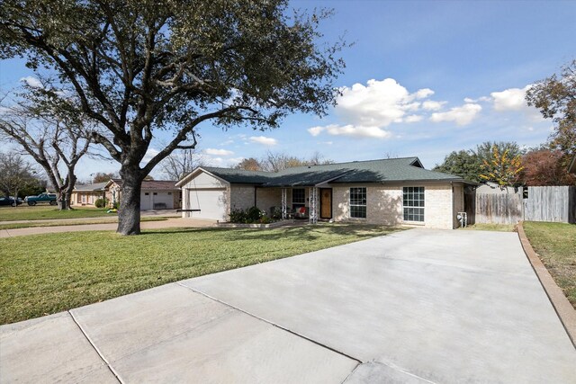 single story home featuring a garage and a front yard