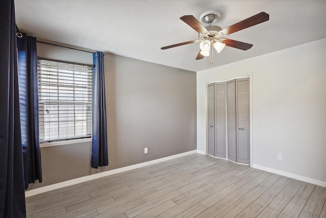 unfurnished bedroom featuring ceiling fan, light wood-type flooring, and a closet