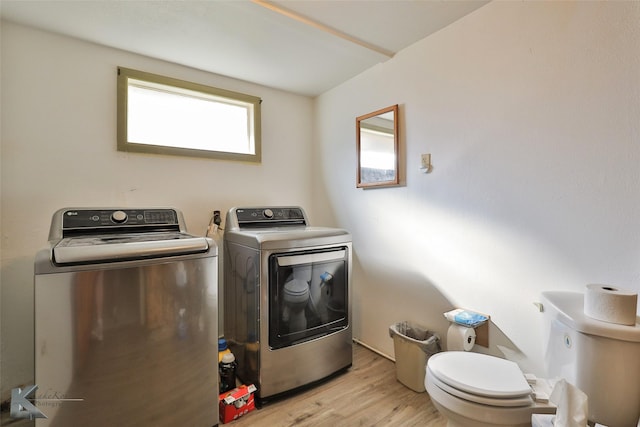 washroom with washer and clothes dryer and light hardwood / wood-style floors