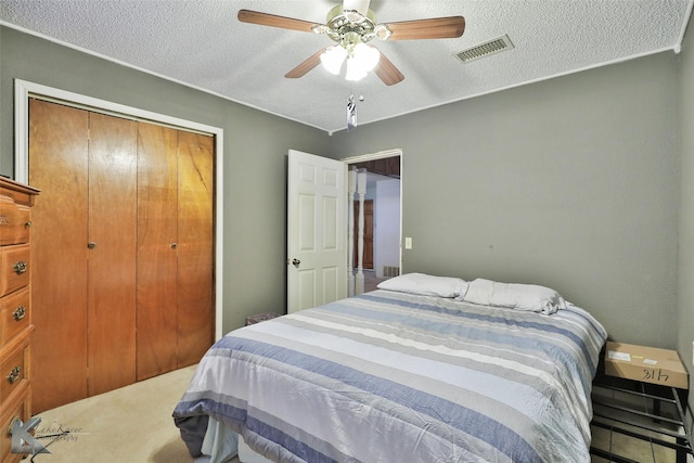 carpeted bedroom with a textured ceiling, a closet, and ceiling fan