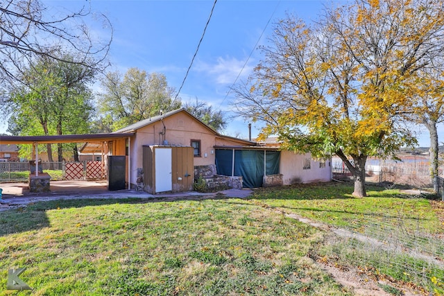 rear view of house with a lawn and a carport