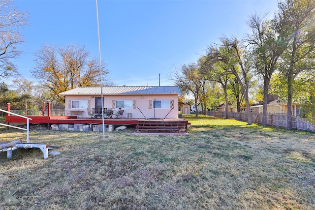 back of property featuring a lawn and a wooden deck